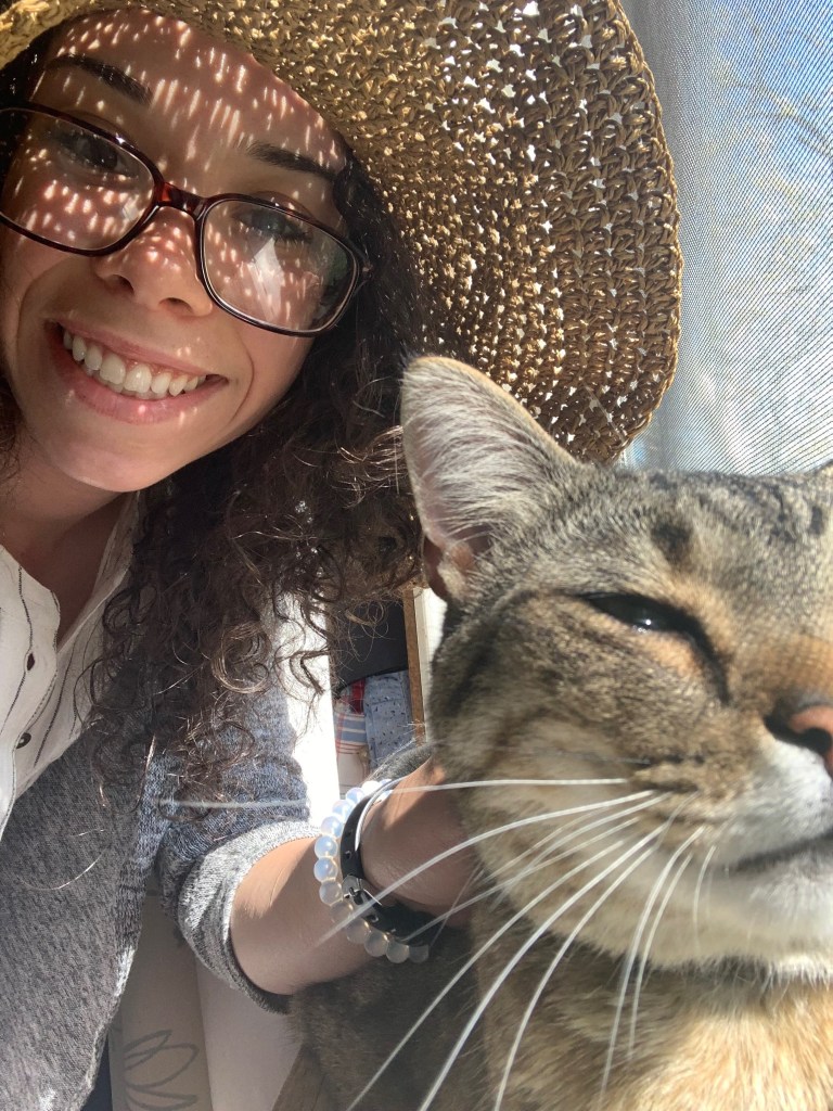 Close-up of a cat being held by a person wearing bracelets